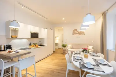 a kitchen and living room with a table and chairs at Colosseum Holidays - Three-Bedroom Apartment in Rome