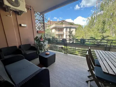 a balcony with a table and chairs and a view at Moderno bilocale con terrazzo in Rome