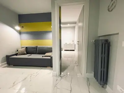 a living room with a gray couch and a yellow and blue wall at Vatican Tiny House in Rome