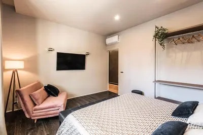 a bedroom with a bed and a chair and a television at Saint Peter Vatican luxury apartment in Rome