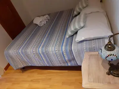 a bed with a blue comforter and a wooden table at Loft Shabby Chic con vista vicino al Vaticano in Rome