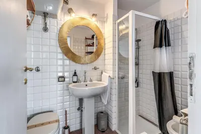 a white bathroom with a sink and a mirror at Terrazza Ippocrate in Rome