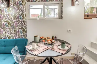 a table with two chairs and a table with food on it at Terrazza Ippocrate in Rome