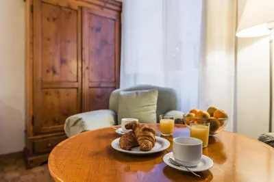 a table with plates of croissants and cups of orange juice at Carla Luxury House in Rome