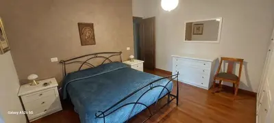 a bedroom with a bed and a dresser and a chair at Tra le antiche mura e Garbatella in Rome
