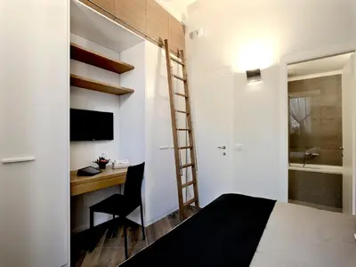 a bedroom with a desk and a bed and a ladder at Antiche Residenze Romane Navona in Rome
