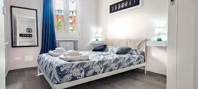 a small bedroom with a bed with blue and white sheets at Rome Essence Apartament in Rome