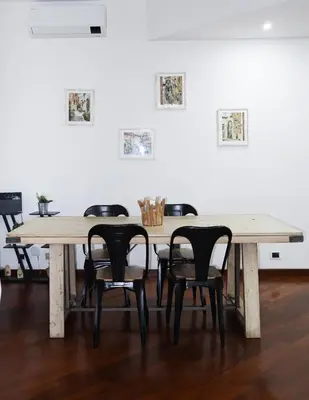 a table and chairs in a room with paintings on the wall at Cozy Home San Giovanni in Rome