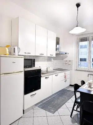 a kitchen with white cabinets and a black oven at Cozy Home San Giovanni in Rome
