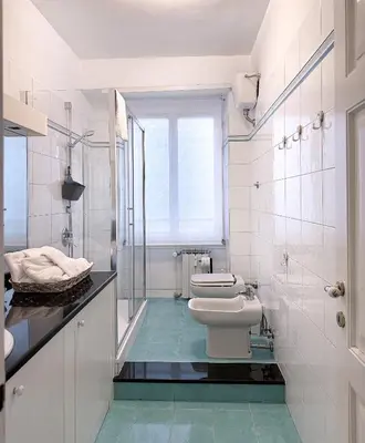 a white bathroom with a toilet and a sink at Cozy Home San Giovanni in Rome
