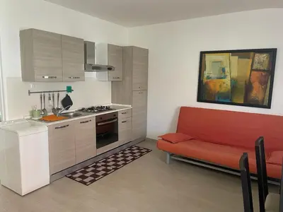 a kitchen with a red couch in a room at BORGO PESCI in Rome