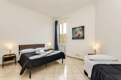 a bedroom with two beds and a window at Magenta Tiburtino in Rome