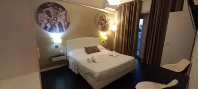a hotel room with a bed and two chairs at Casa Felicita in Rome