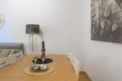 a dining room table with a wine bottle and glasses at Appartamento Barsanti in Rome
