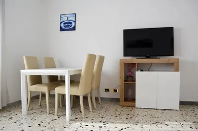 a white dining room table with chairs and a television at La Casa di Dany in Rome