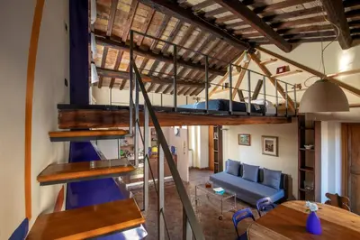 a loft bed in a room with tables and benches at Dimora degli Acetari in Rome