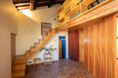 a hallway with wooden stairs and a table with a plant at Dimora degli Acetari in Rome