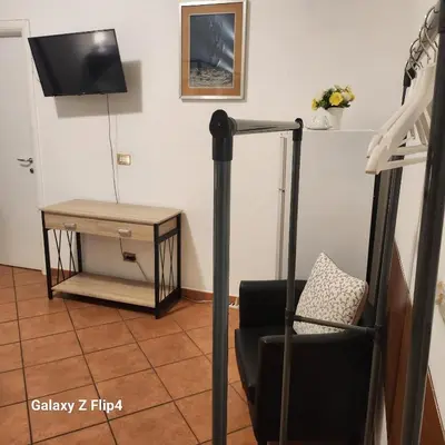 a living room with a chair and a television at SweetHouseVittorio in Rome