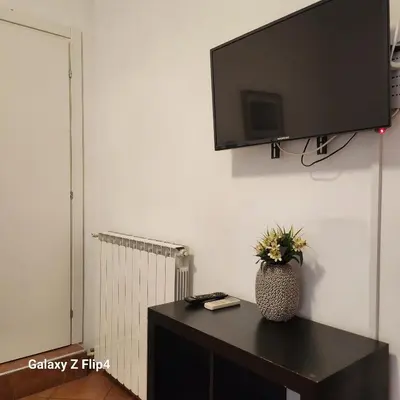 a television on a wall with a vase on a table at SweetHouseVittorio in Rome