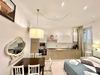 a kitchen and living room with a table and a dining room at Vacanze Romane Laterano in Rome