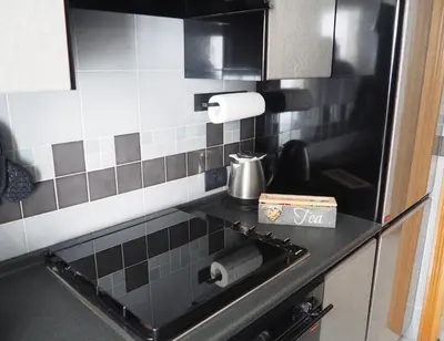 a kitchen with a black and white tiled wall at Appartamento Vacanze Romane in Rome