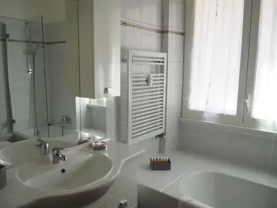 a white bathroom with a sink and a tub at Appartamento Vacanze Romane in Rome