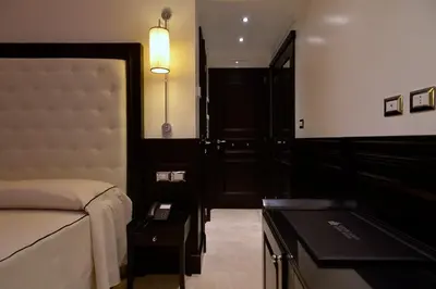 a bedroom with a bed and a table with a lamp at Vaticano Royal Suite Guest House in Rome