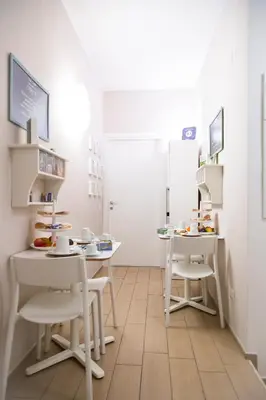 a room with two white tables and chairs at B&B Casetta Roma in Rome
