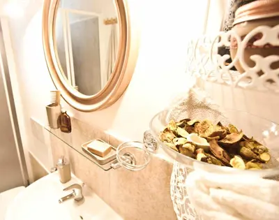 a bathroom with a sink with a mirror and a bowl of shells at SottosopraSannio in Rome