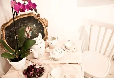 a table with a vase of flowers and a plate of tea sets at SottosopraSannio in Rome