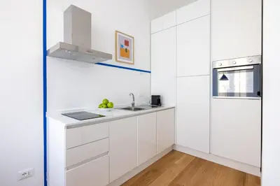 a white kitchen with white cabinets and a sink at Little Gaia Suite in Rome