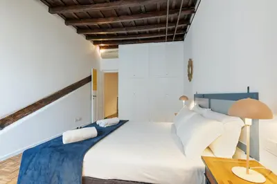 a bedroom with a large white bed and a desk at Rome As You Feel - Santa Margherita Design Apartment in Rome