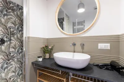 a bathroom with a sink and a mirror at Rome As You Feel - Santa Margherita Design Apartment in Rome