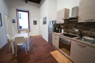 a kitchen with a table and a sink and a stove at Residenza Bernini in Rome