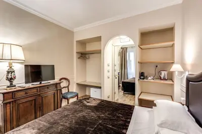 a bedroom with a bed and a desk and a television at Aurelius Ponte Sant'Angelo in Rome