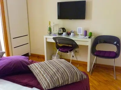a bedroom with a desk with two chairs and a monitor at L'Appartamento Romano in Rome