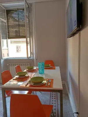 a dining room with a table with chairs and a refrigerator at La CASA DI SABINA in Rome