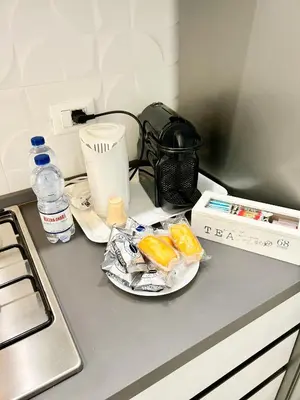 a kitchen with white cabinets and a table and a refrigerator at Roma Apartment holiday in Rome
