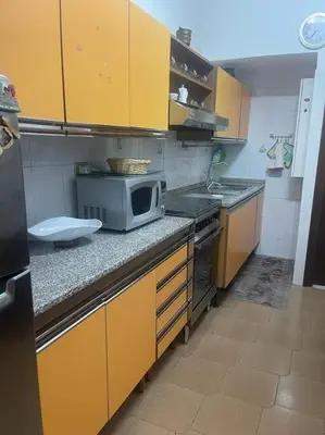 a kitchen with yellow cabinets and a microwave on a counter at Casa vacanze Pigneto Roma in Rome