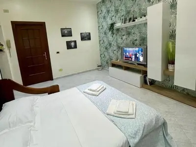 a bedroom with a white bed and a tv at Casa vacanze Pigneto Roma in Rome
