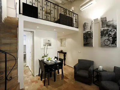 a living room with a table and chairs and a staircase at Antiche Residenze Romane - CAMPO DE' FIORI in Rome