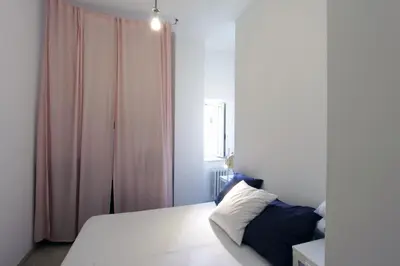 a bedroom with a bed and a pink curtain at Cattaneo Flat in Rome