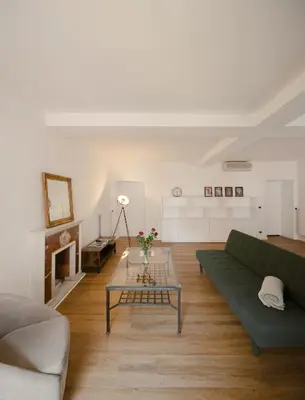 a living room with a green couch and a table at Via Francesco Crispi Private Apartment in Rome