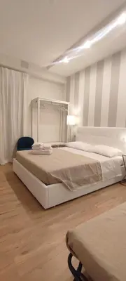 a bedroom with a large bed and a chair at Portonaccio suite - Stazione Tiburtina - Università - Metro B in Rome