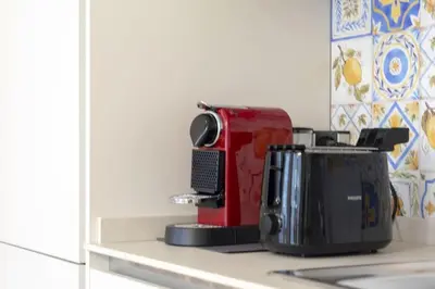 a red appliance sitting on top of a kitchen counter at Vatican Steps, Suite Mary, Strollingrome in Rome