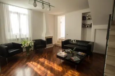 a living room with black leather furniture and a fireplace at Relais Arco Della Pace in Rome