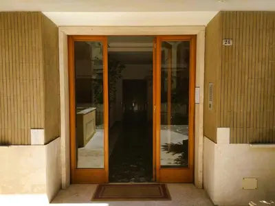 an entrance to a building with two glass doors at Casa con Giardino - Metro A Cornelia Vaticano a sole 4 fermate in Rome