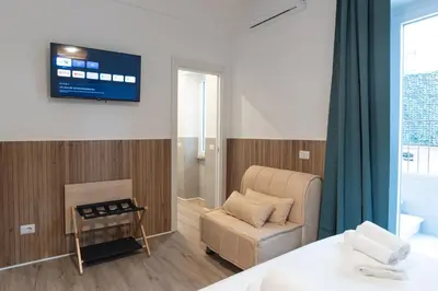 a room with a couch and a chair and a television at Residence San Paolo in Rome