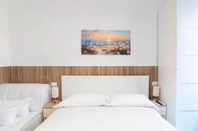 a bedroom with two beds and a painting on the wall at Residence San Paolo in Rome