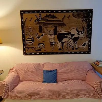 a tapestry hanging on a wall above a couch at HOUSE UP TO THE HILL - stanza con soggiorno a Monteverde vecchio in Rome